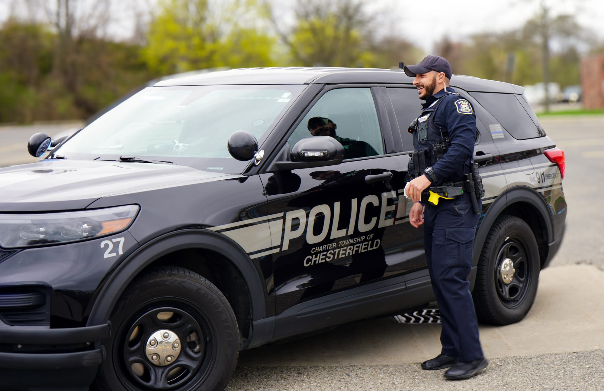 Chesterfield Township patrol officer standing beside his police SUV