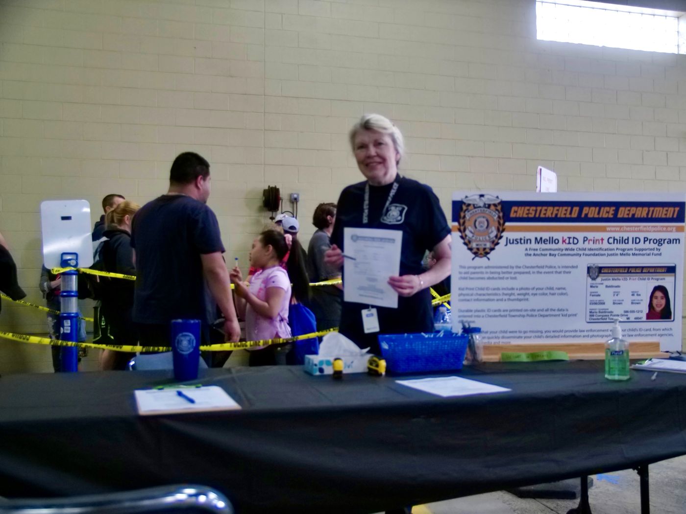 A kID Print volunteer holding a finished ID card