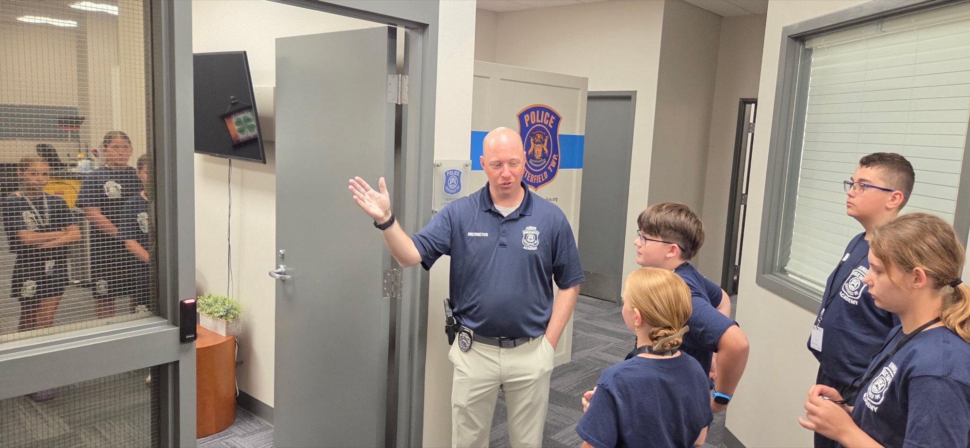 Officer Ryan Wilson leading Junior Public Safety Academy students on a station tour